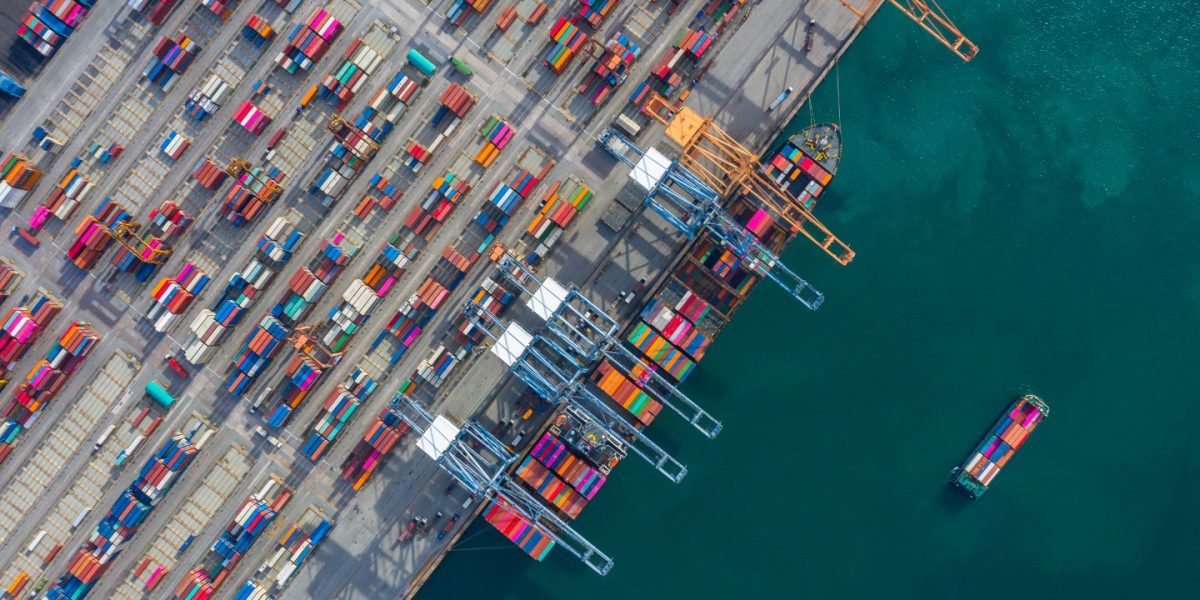 aerial-view-cargo-ship-terminal-unloading-crane-cargo-ship-terminal-aerial-view-industrial-port-with-containers-container-ship-1440x800